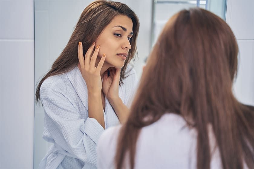 4. Image of a worried woman looking at her face.jpg