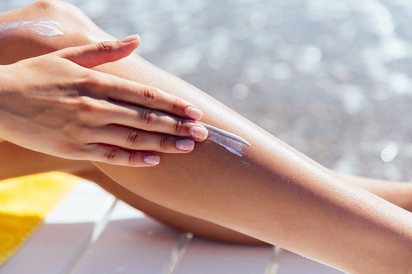 9 Common Mistakes to Avoid When Choosing a Face Cream for Women 3 close up view female hand applying sunscreen her leg near sea